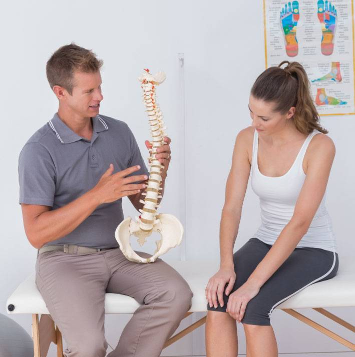 Chiropractor Showing Woman Spine Vertebrae Disc Model