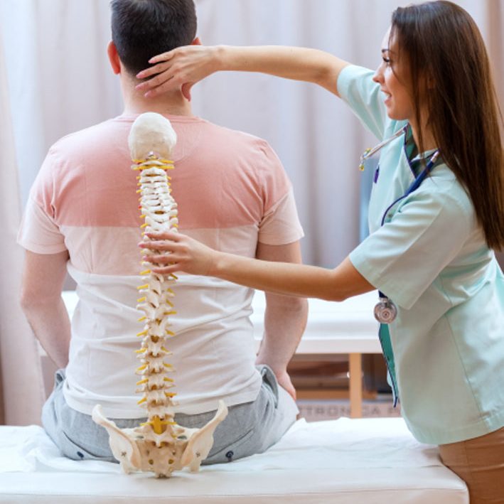 Female Singapore Chiropractor Demonstrating Spine Adjustment with Model